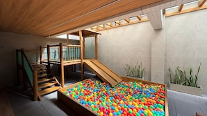 A play area with a ball pit, wooden play structures, and a staircase. - Edifício HIGH (Maceió)
