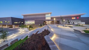 A modern building with a flat roof, large windows, and a sign reading 'Brookfield Residential YMCA at Seton.' - Modern Suite in Seton - King Bed, 85" TV, Near South Health Campus & YMCA (Calgary)
