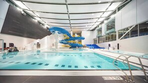 Una piscina interior con tobogán y vista despejada del borde de la piscina.