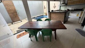 A modern kitchen with a dining area, large windows, and a view of a swimming pool. - Cozy rooms for rent (Belém)