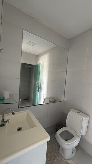A bathroom with a sink, toilet, and a large mirror. - Cozy rooms for rent (Belém)