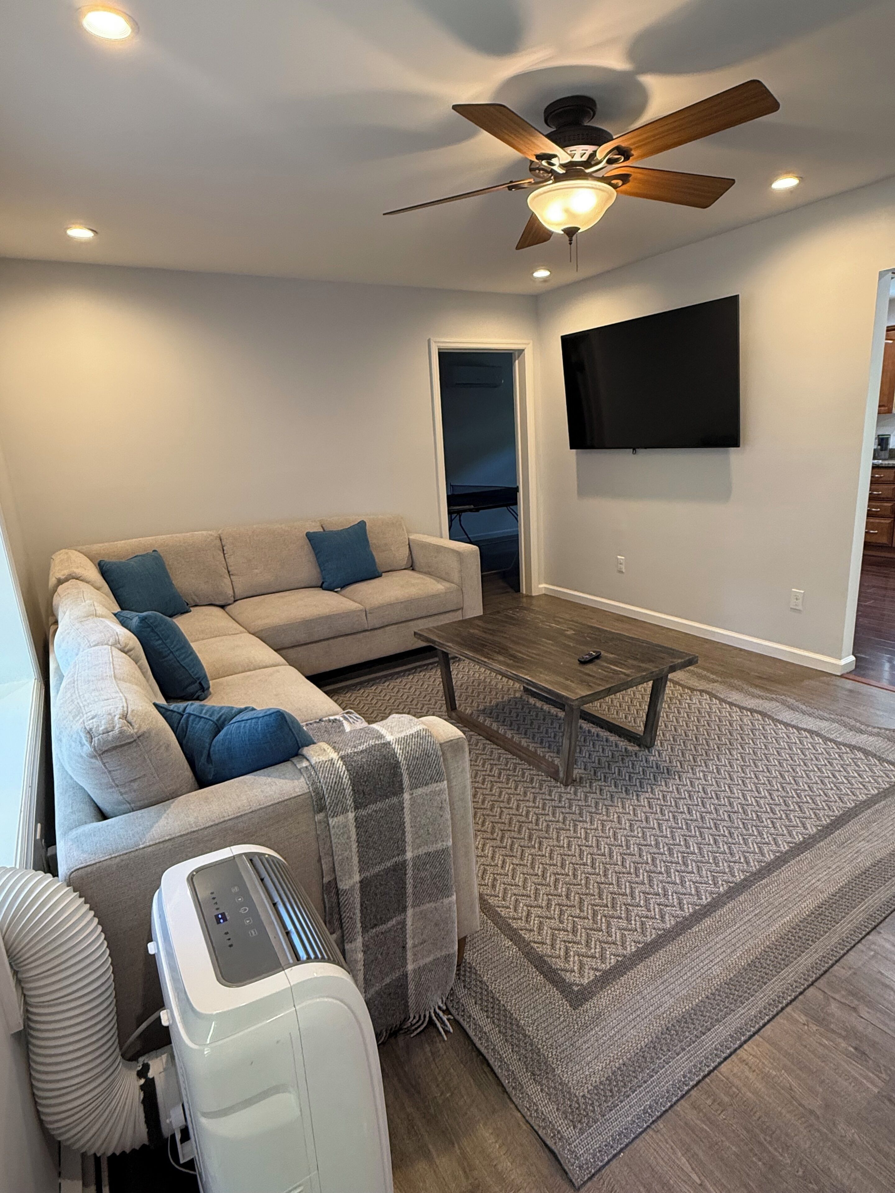 A living room with a sofa, coffee table, and a ceiling fan.