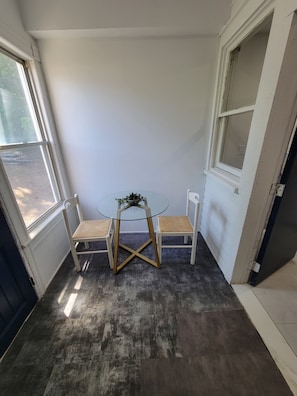 A corner room with a glass table, two wicker chairs, and a view through a window. - 3BR Passaic Home Near NY/NJ Stadium, NYC Access, Sleeps 6 (Passaic)