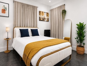 Une chambre à coucher moderne avec un lit, des rideaux, un tableau, une lampe sur pied et une plante en pot.