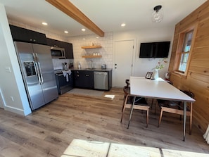 A modern kitchen with a built-in oven, microwave, and stainless steel refrigerator.