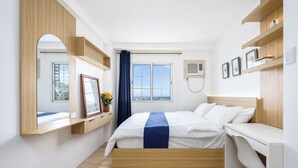 Een hotelkamer met een bed, bureau en een raam met uitzicht.