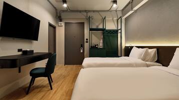 A hotel room with a bed, a desk, a chair, a television, and a bathroom door.