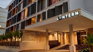 Een modern hotel met een opvallend 'L'ONTERN'-bord, meerdere verdiepingen en een gevlinderd gevelontwerp.