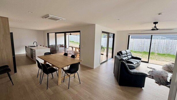 Una cocina moderna con comedor, sofá y vistas al exterior.