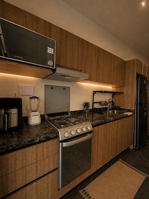 Eine moderne Küche mit eingebauter Mikrowelle, Herd, Backofen und Kühlschrank.