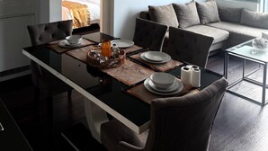Un soggiorno moderno con zona pranzo, divano e finestra con tende.