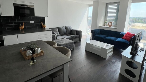 Een modern appartement met keuken, eethoek en woonkamer.