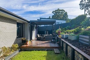 A modern house with a deck, outdoor seating, and a garden. - Marlin Vista - Pet friendly, fenced yard (Eden)