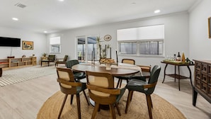A dining area with a round table, chairs, and a buffet table. - The Southwind|Pool|3-Min Drive to Beach|Sleeps 10 (St. Augustine)