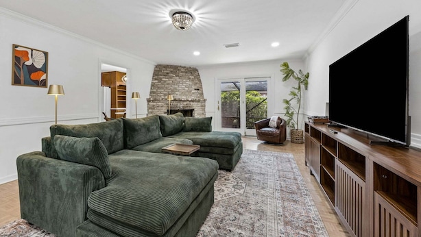 A living room with a sectional sofa, a fireplace, a television, and a large window. - The Southwind|Pool|3-Min Drive to Beach|Sleeps 10 (St. Augustine)