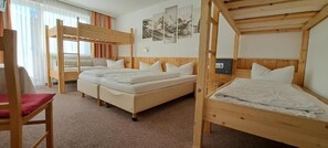Quarto com beliches, uma cadeira e um radiador.