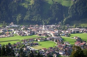 A town with a prominent church, green fields, and residential buildings.