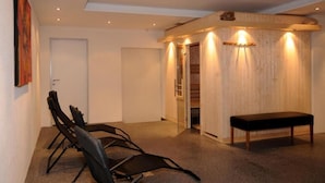A room with a bench, chairs, a wooden wall, and a door.