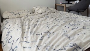 Un dormitorio con cama, escritorio con ordenador y silla.