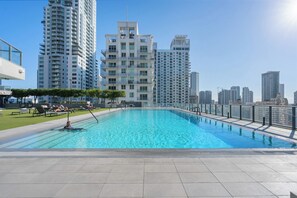 Ein Pool auf dem Dach mit Stadtansicht im Hintergrund.