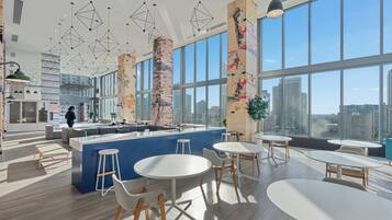 A modern interior with a central bar area, round tables, and high ceilings with geometric light fixtures.