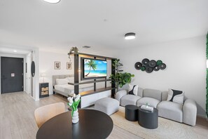 Ein modernes Wohnzimmer mit Fernseher, Sofa, Couchtisch und Dekorationselementen.