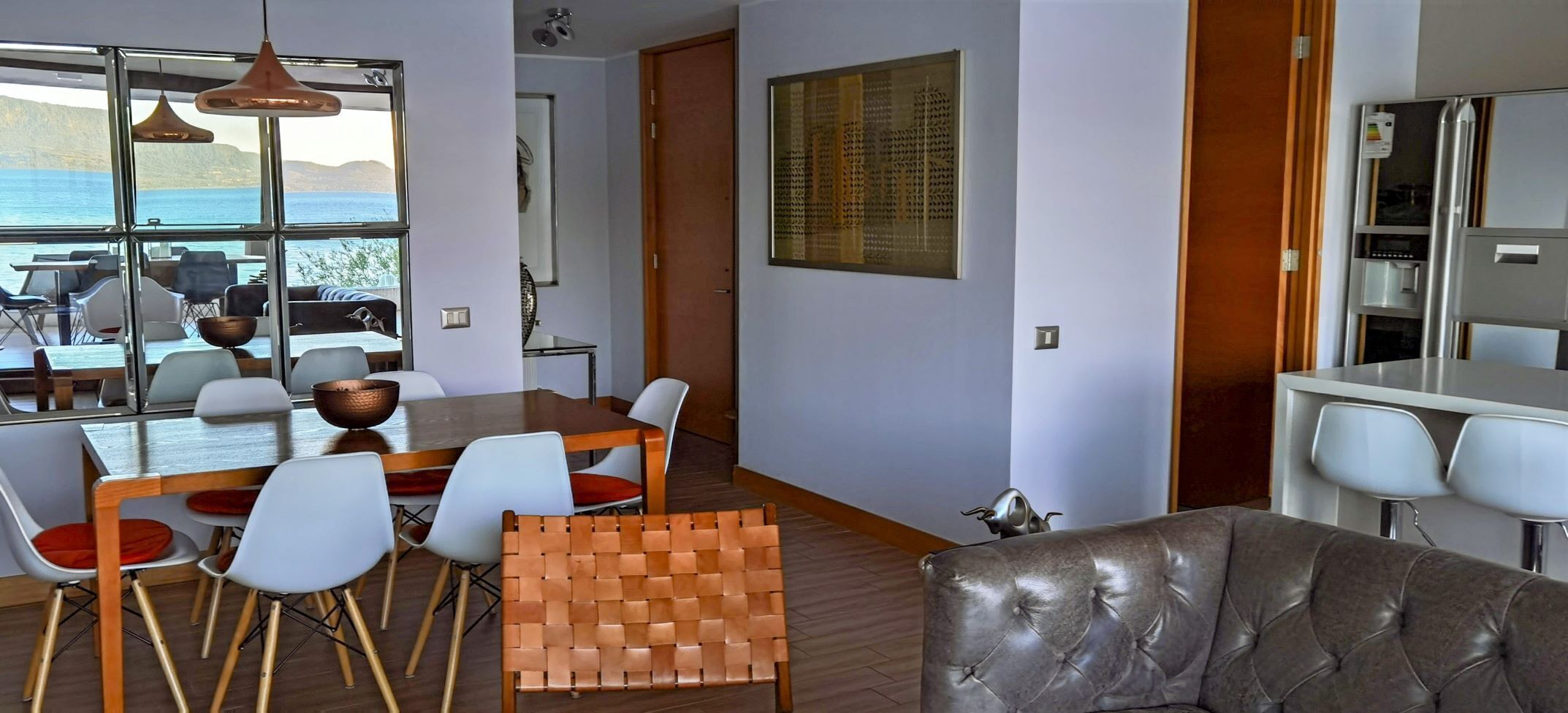 Un interno moderno con zona pranzo, divano e cucina.