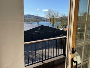 A view from a balcony overlooking a lake, a building with a sign 'Halls Boat Corporation,' and a clear sky.