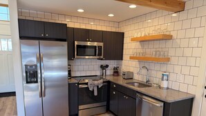 A modern kitchen with stainless steel appliances, a microwave, and a built-in oven. - Deluxe Lodge Lakefront On Lake George #11 (Lake George)