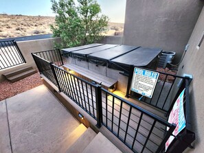 A pool area with a covered deck, steps leading to the pool, and a sign listing pool rules. - The Desert Dip Oasis at Lake Powell with swim spa!
 (Page)