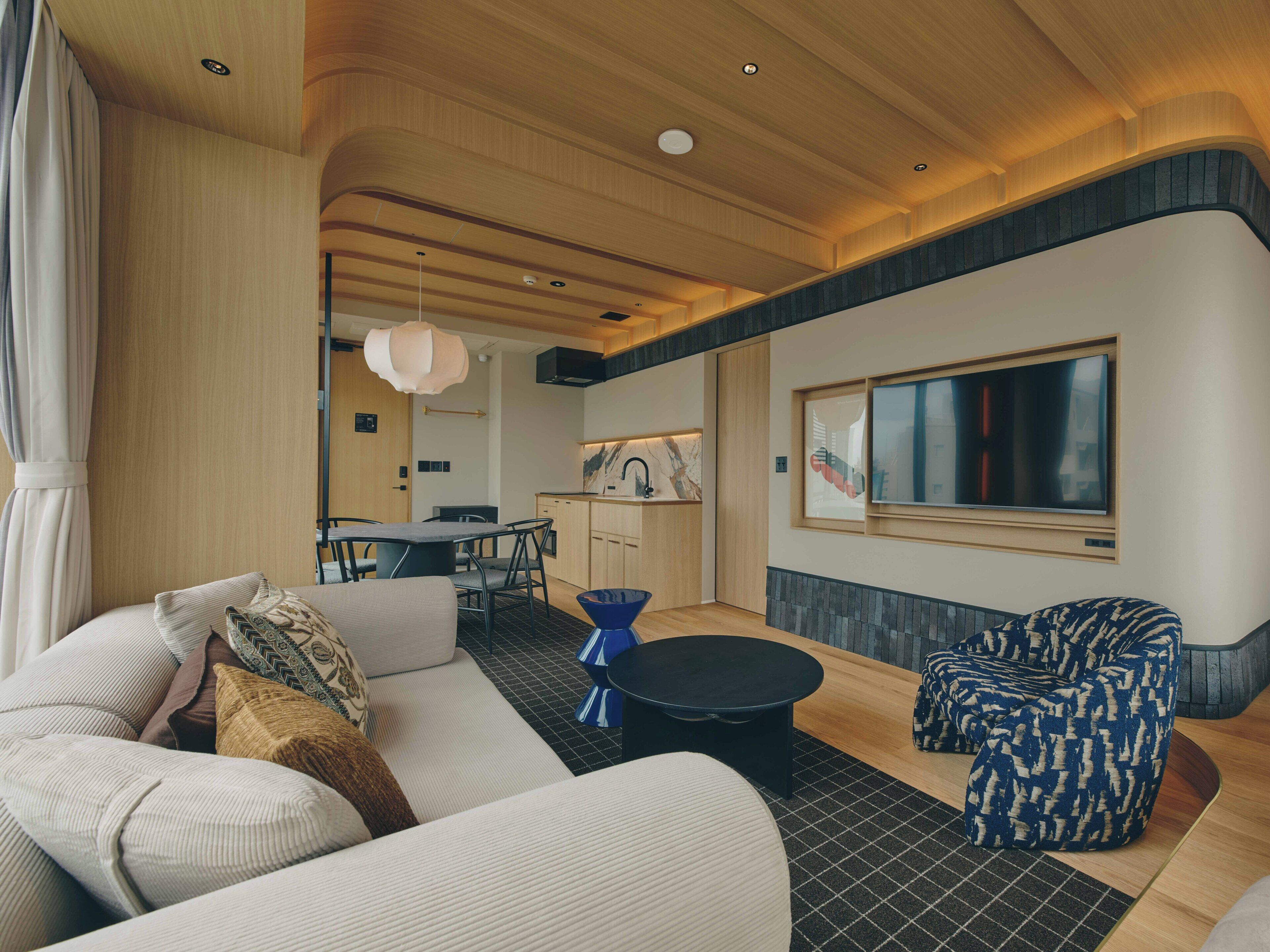 Una sala de estar moderna con un sofá, una mesa de centro y sillones estampados.