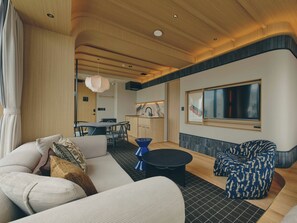 A modern living room with a sofa, a coffee table, and patterned chairs.