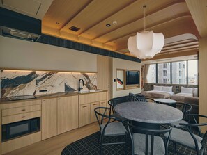 A modern kitchen with a marble backsplash, wooden cabinets, and a dining area with a round table and chairs.