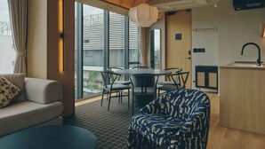 Un intérieur moderne comprenant un canapé, une table à manger, des chaises et un coin cuisine.