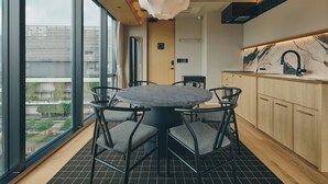 Una cocina moderna con una mesa redonda y sillas, armarios de madera y un ventanal grande.