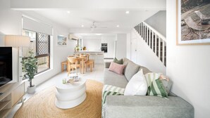 A modern living room with a sofa, coffee table, and dining area.
