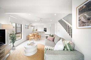 Ein modernes Wohnzimmer mit Sofa, Couchtisch und Essbereich.