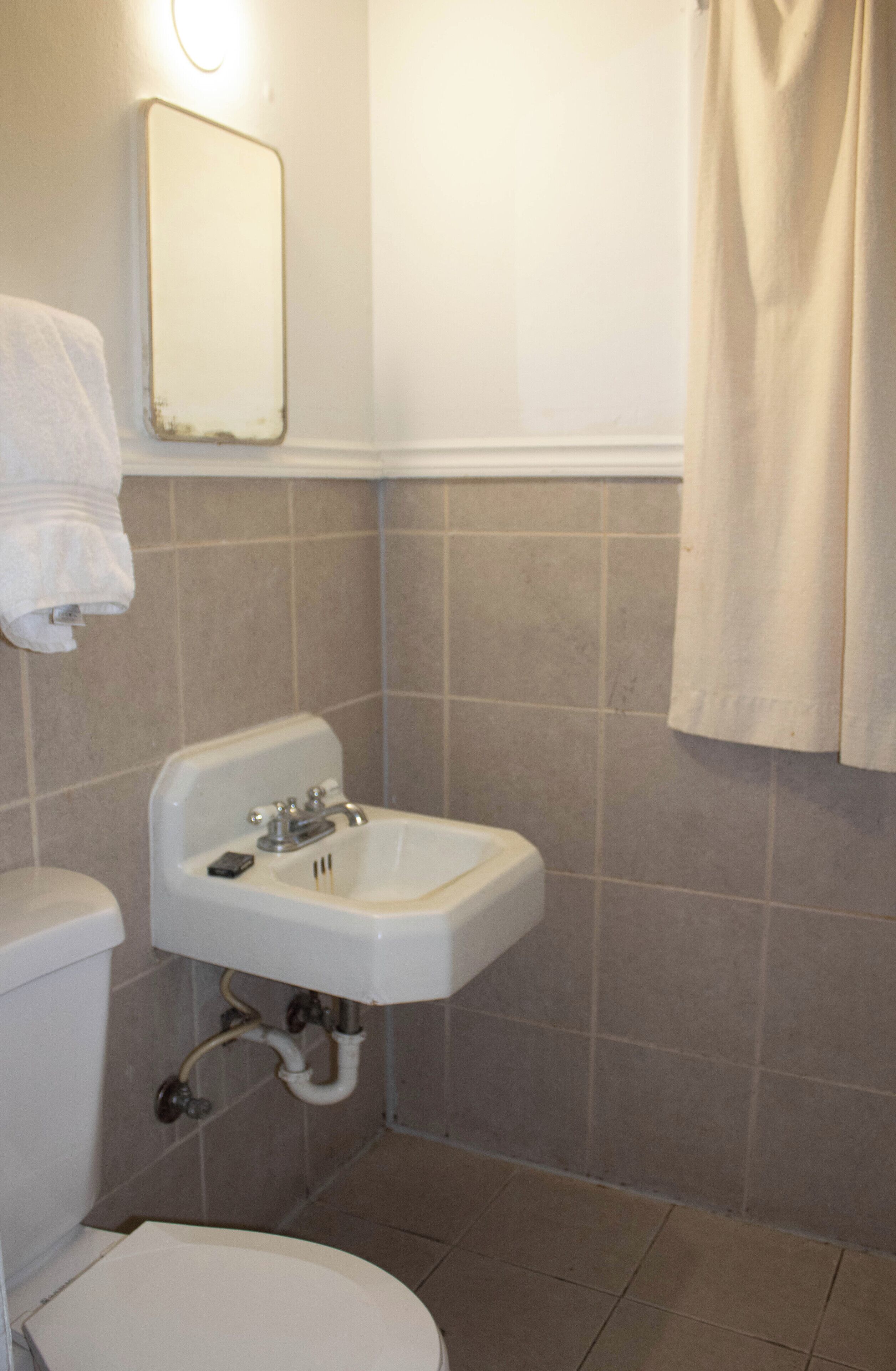 Un baño con inodoro, lavamanos y espejo.