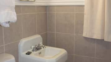 Un baño con inodoro, lavamanos y espejo.