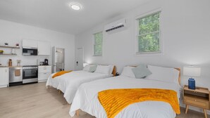 A modern hotel room with two beds, a kitchenette, and a bathroom. - Pet Friendly sleeps 10 Fenced Yard Garage Studio (Smithfield)