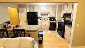 Cocina compacta con refrigerador, microondas, estufa y lavavajillas.
