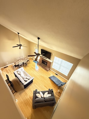 A spacious loft with a dining area, a sofa, a fireplace, and a TV. - Cozy Townhome in Marietta! (Marietta)