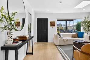 Un salon moderne avec un canapé, une table basse et une vue sur l’extérieur.
