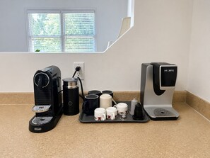 Un coin café équipé d’une machine à café Keurig, d’une autre machine à café de la marque Mr. Coffee, et d’un plateau avec des tasses et une cafetière.