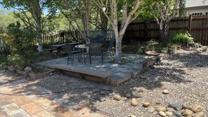 Eine Terrasse mit Sitzgelegenheit, einem Feuerkorb und einem Holzboden.