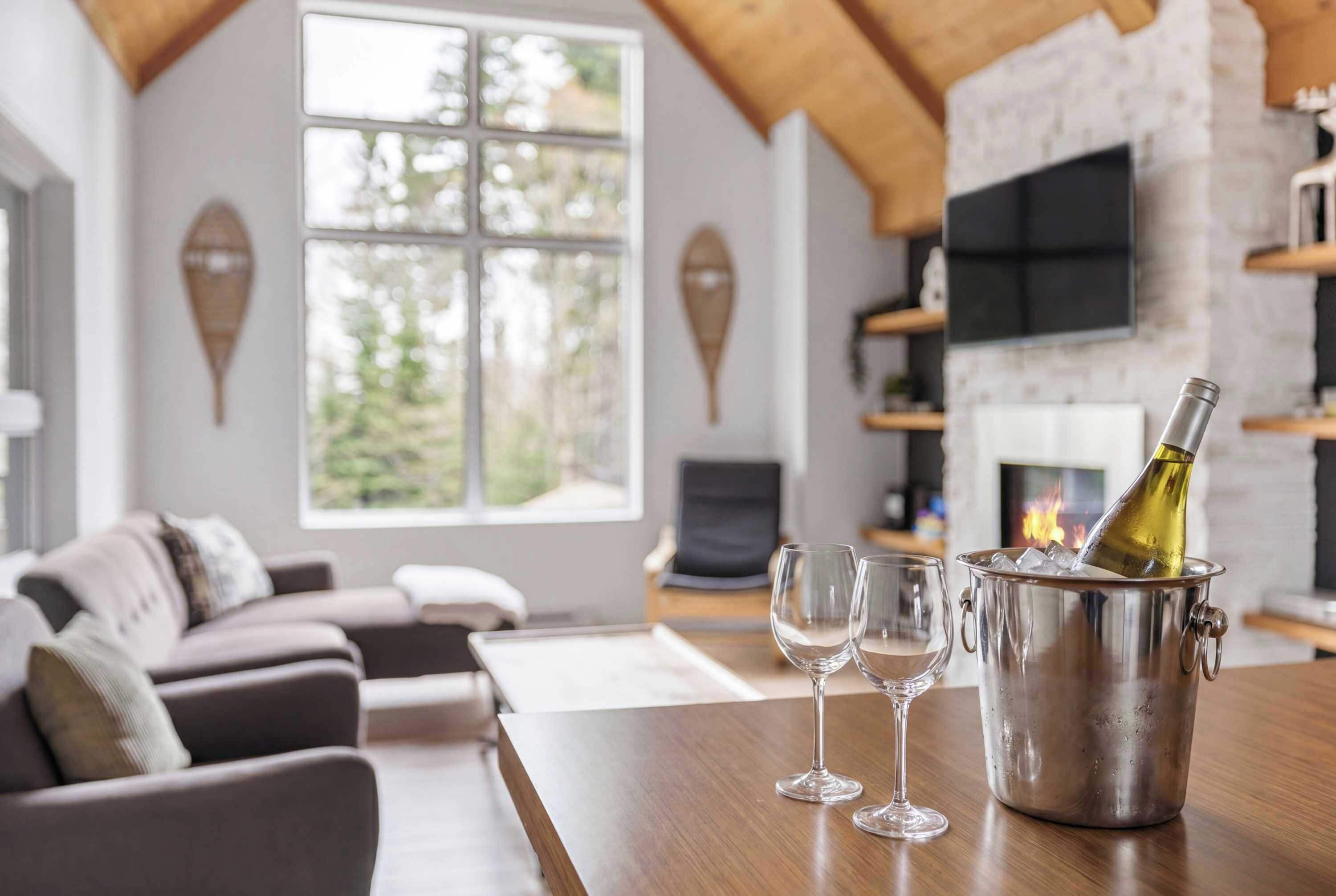 Un salon moderne avec une cheminée, une grande fenêtre et un coin salon confortable.