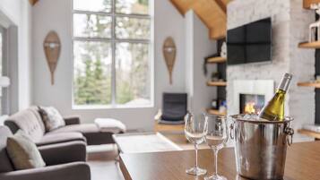Un salon moderne avec une cheminée, une grande fenêtre et un coin salon confortable.