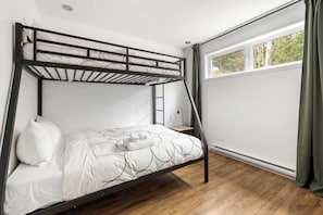 A bunk bed with a ladder, white bedding, a wooden floor, a window with curtains, and a small bedside table. - Aurore Spa Prive Coin Feu BBQ 8 Pers by Alchalet (Petite-Rivière-Saint-François)