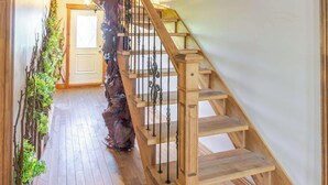 A wooden staircase with a decorative tree trunk and metal balusters. - Chateau De Valvak  Spa & BBQ  Free Parking (Lévis)