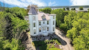 A large, light-colored building with a symmetrical facade, multiple windows, and a central entrance with a porch. - Chateau De Valvak  Spa & BBQ  Free Parking (Lévis)